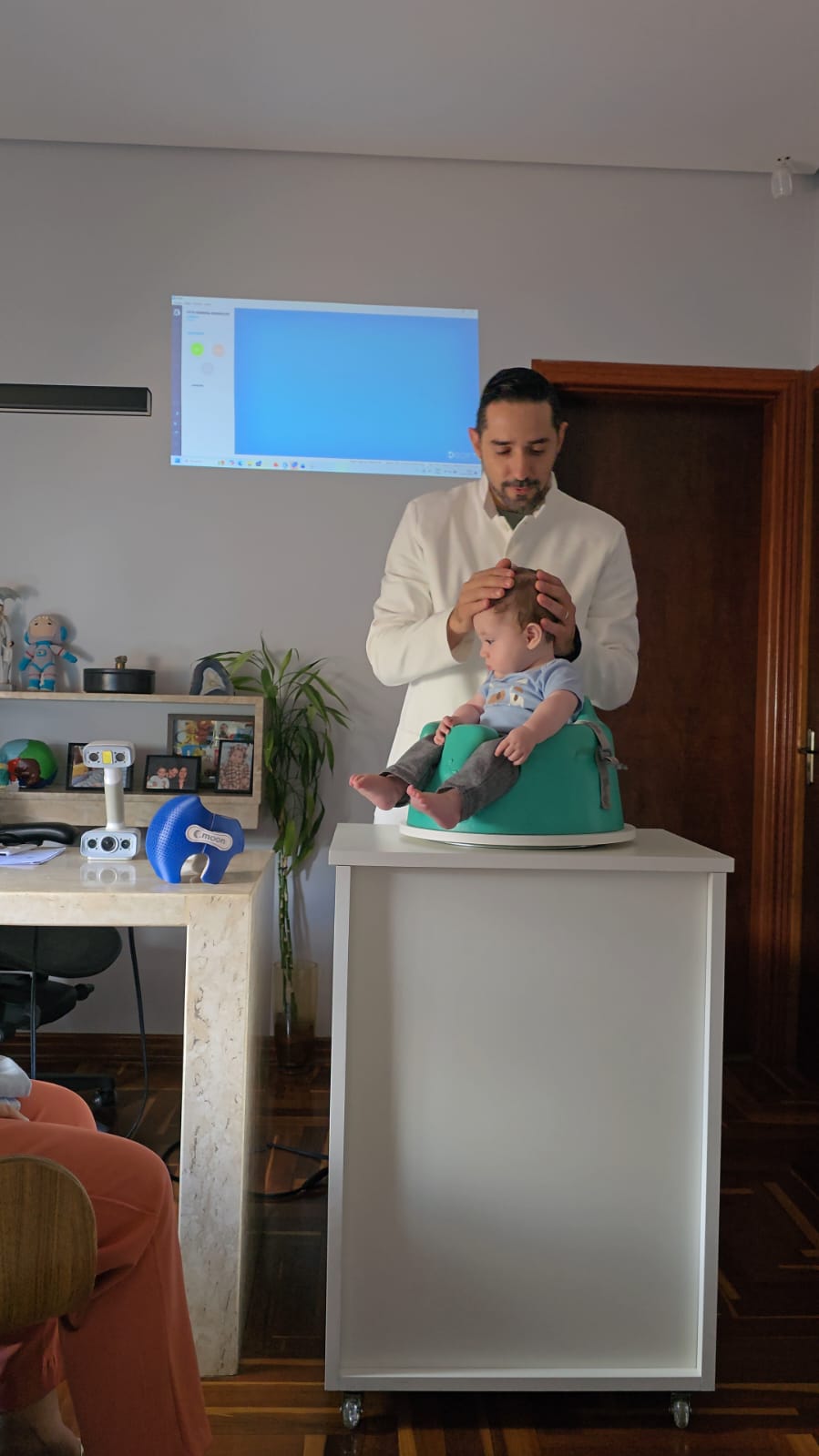 Especialista avaliando a cabecinha do bebê com as mãos