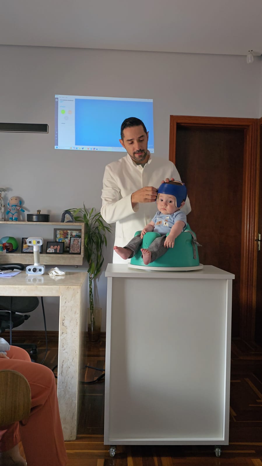Bebê tranquilo usando a órtese craniana azul feita sob medida